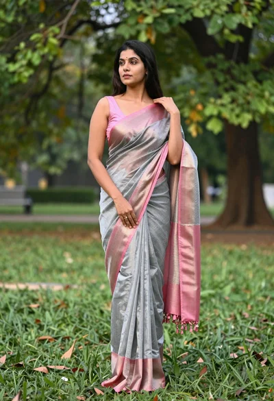Full length portrait of woman in saree standing in lush green park