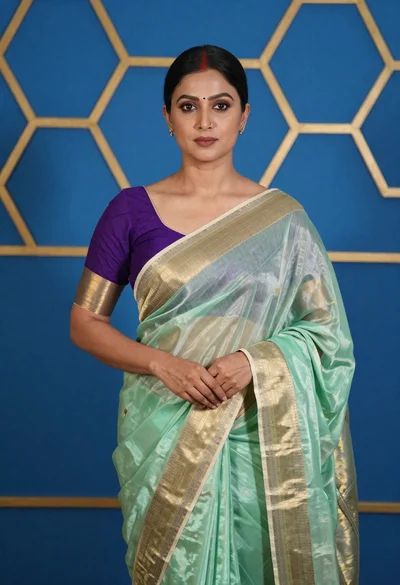 Poised woman in light green saree against blue honeycomb background