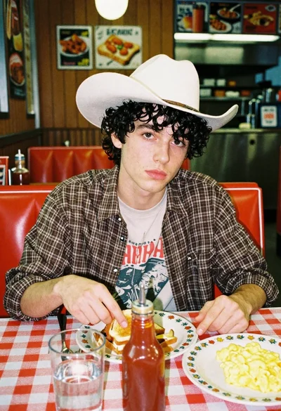 Young man eating breakfast in a retro diner booth