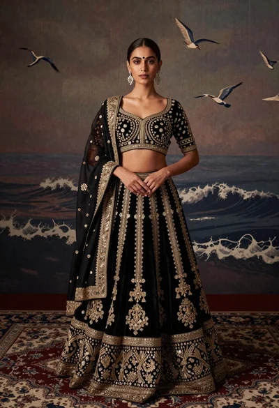 Young woman in black and gold lehenga choli standing on patterned rug
