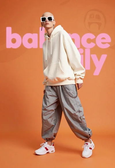 Fashion model in white hoodie against orange background