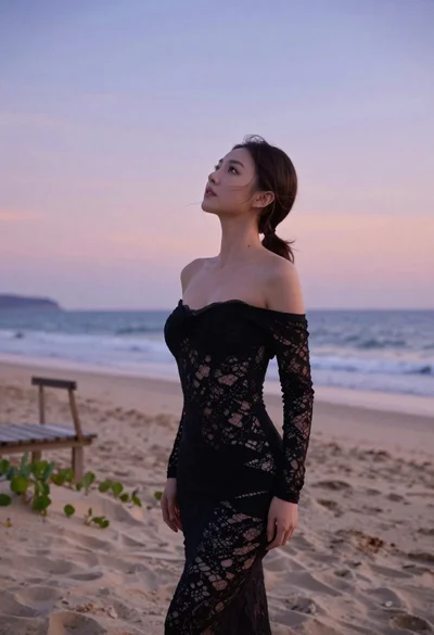 Brunette woman in black lace dress on sandy beach at twilight