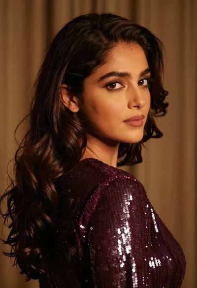 Close up portrait of woman with dark brown hair looking over shoulder