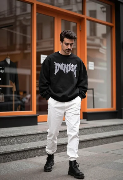 Stylish man in black sweatshirt on city sidewalk near orange storefront