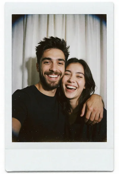 Candid portrait of laughing couple against white curtain backdrop