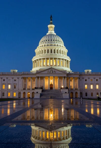 Low angle view of united states capitol dome reflecting in plaza at