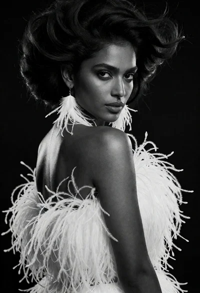 Dramatic black and white portrait of woman in feathers looking over shoulder