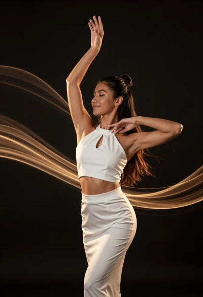 Fit woman in white outfit posing with golden light ribbons against black