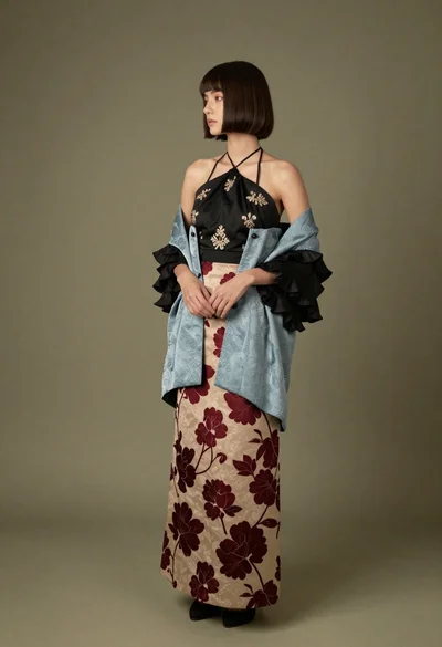 Full length studio portrait of woman in embroidered jacket and skirt