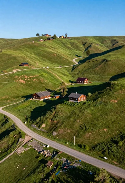 Aerial view of rolling green hills with traditional wooden houses under blue