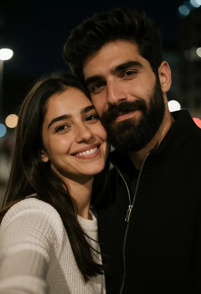Close up selfie of smiling woman and bearded man at night