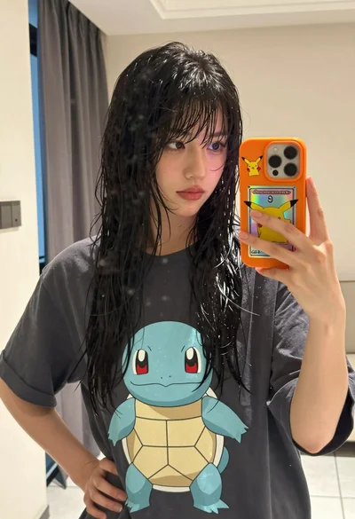 Young woman taking mirror selfie in oversized tshirt indoors