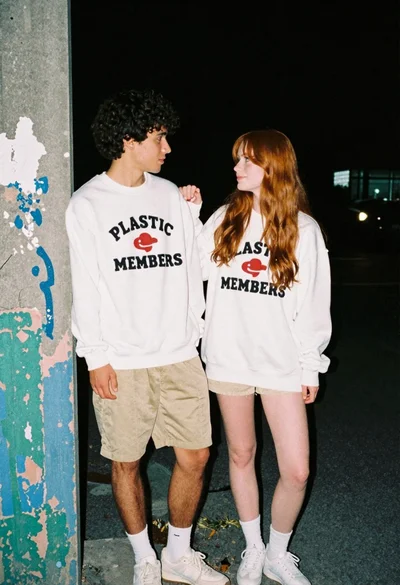 Young couple standing against weathered concrete wall at night