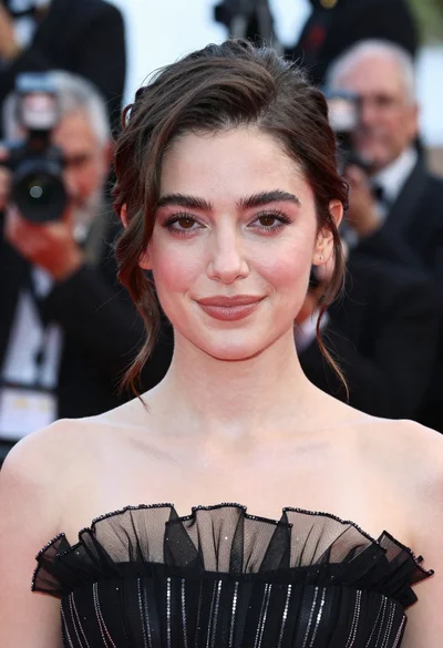Close up portrait of woman in black gown at red carpet event