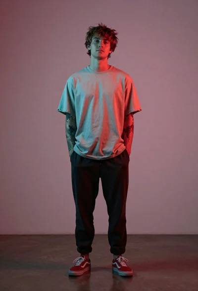 Young man in beige t shirt studio portrait with colored lighting