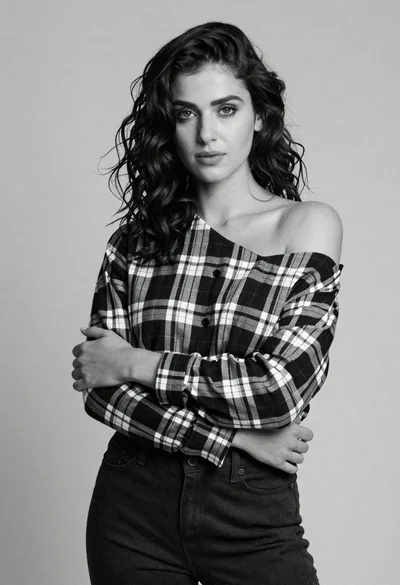 Confident young woman in plaid shirt posing against a light gray studio
