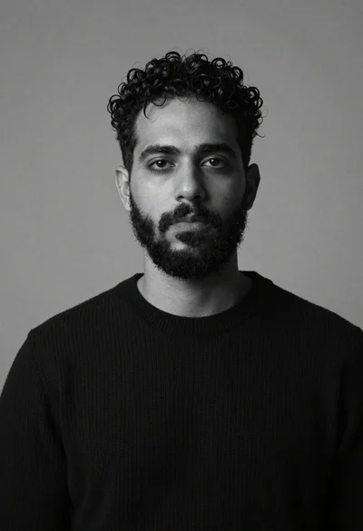 Monochrome studio portrait of bearded man in black sweater