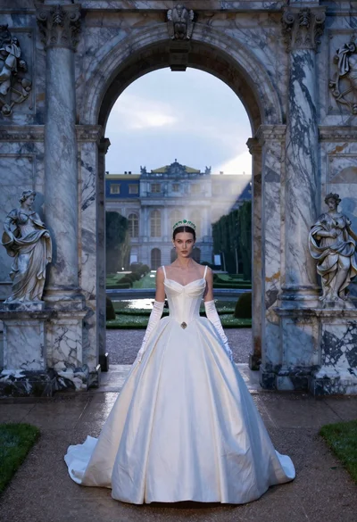 Solo bride emerging from marble archway in classical european palace garden