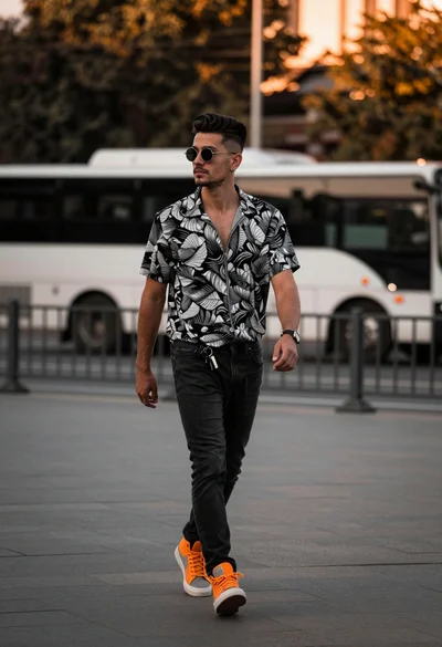 Stylish young man walking down an urban street during golden hour light