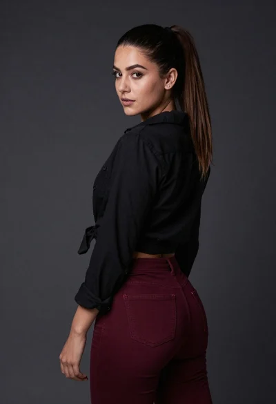 Studio portrait of woman in black shirt and maroon jeans