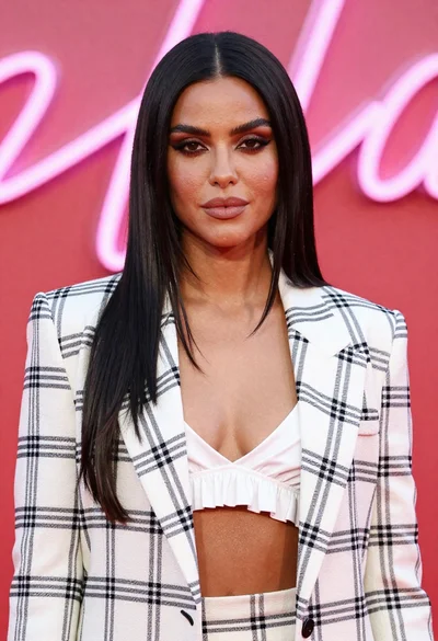 Glamorous woman in white blazer against pink red neon background