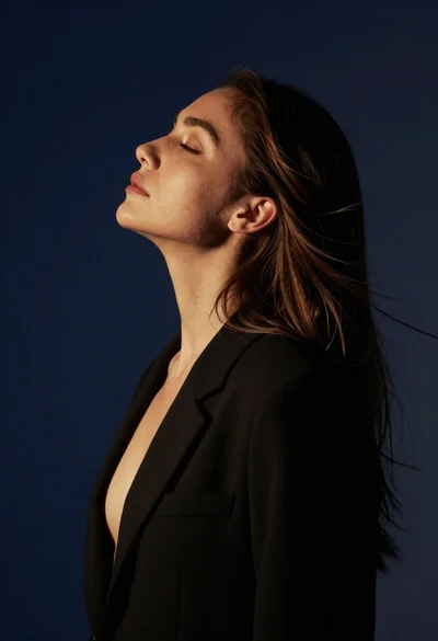 Profile portrait of woman with brown hair and black blazer