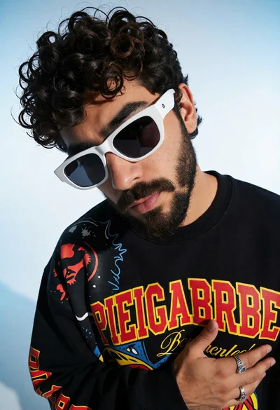 High angle portrait of man with dark curly hair in black sweatshirt