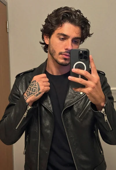 Young man taking a mirror selfie in black leather jacket
