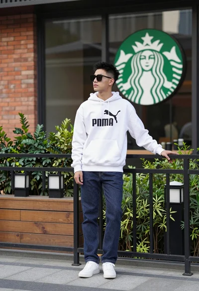 Young man leaning on railing outside modern building with starbucks logo
