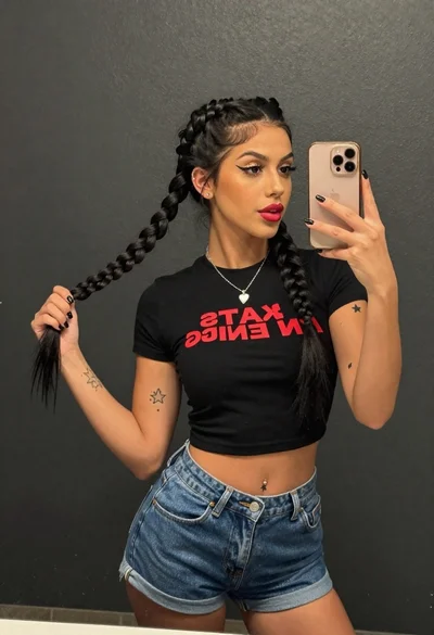Young woman taking a mirror selfie against a dark textured wall