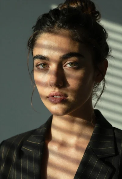 Portrait of woman in black blazer with striped shadows