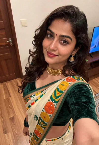 Young woman in green saree taking a close up indoor selfie portrait