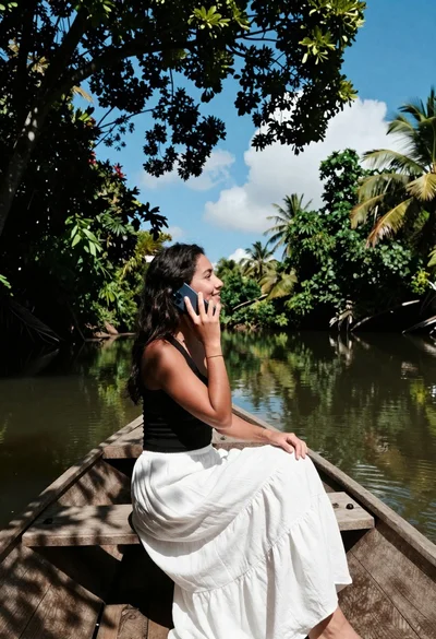 Young woman in white skirt sitting in wooden boat on river