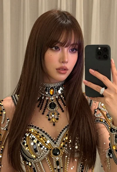 Glamorous woman taking mirror selfie in sheer sequined top