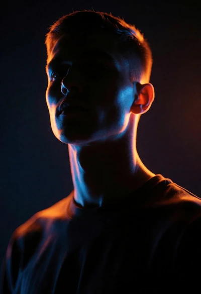 Dramatic portrait silhouette lit by contrasting orange and blue neon glow
