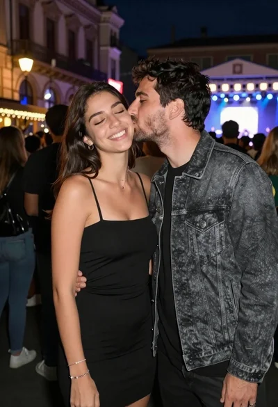 Smiling woman in black dress receives cheek kiss from man in denim