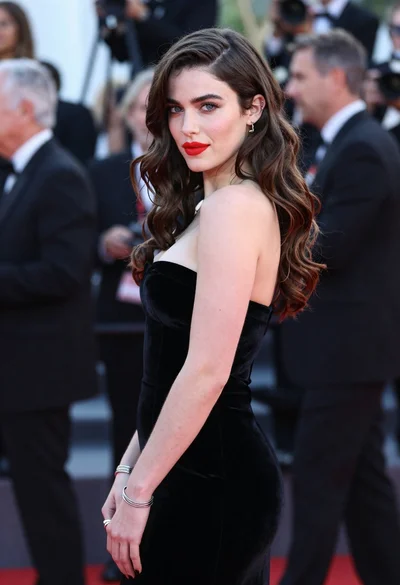 Young woman in black velvet dress looking over shoulder at event