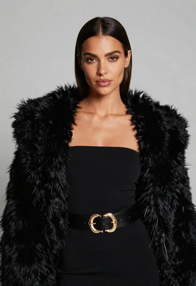 Poised woman in black fur stole against a plain light grey studio