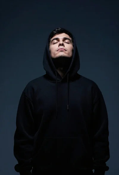 Portrait of man in black hoodie with closed eyes