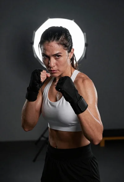 Muscular woman in boxing stance staring intensely at camera