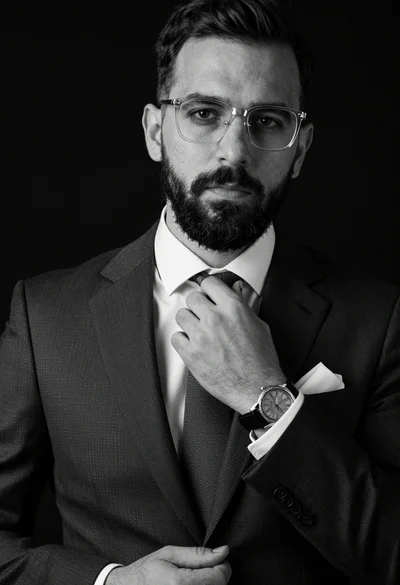 Portrait of a well groomed man adjusting tie in sharp suit against
