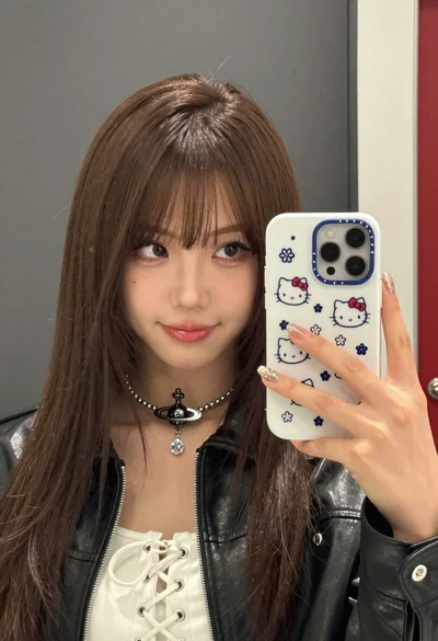 Closeup mirror selfie of young woman in black leather jacket