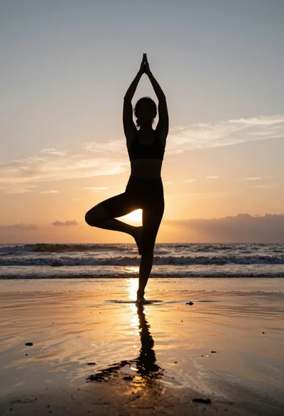 Silhouette of person practicing yoga on a wet beach at sunset