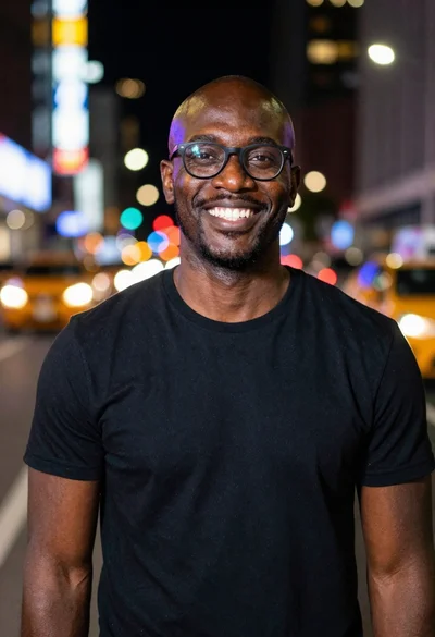 Smiling black man standing on a nighttime city street