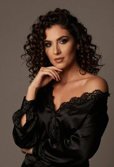 Portrait of woman with dark curly hair in black blouse