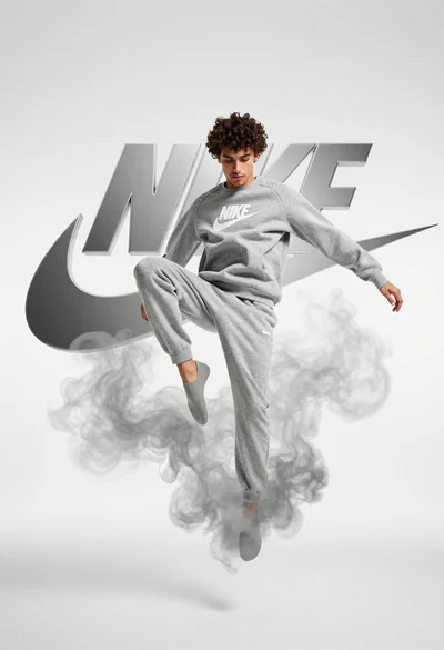 Young man jumping midair in grey sweatsuit against white studio background