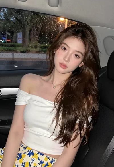 Young woman in white top and floral skirt inside car window