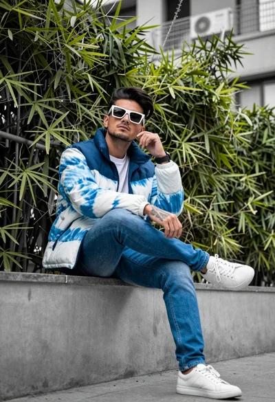 Man sitting on concrete ledge with bamboo backdrop at low angle