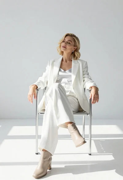 Woman in white fashion outfit sitting in metal chair