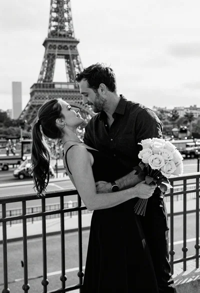 Man and woman embracing in front of eiffel tower on balcony